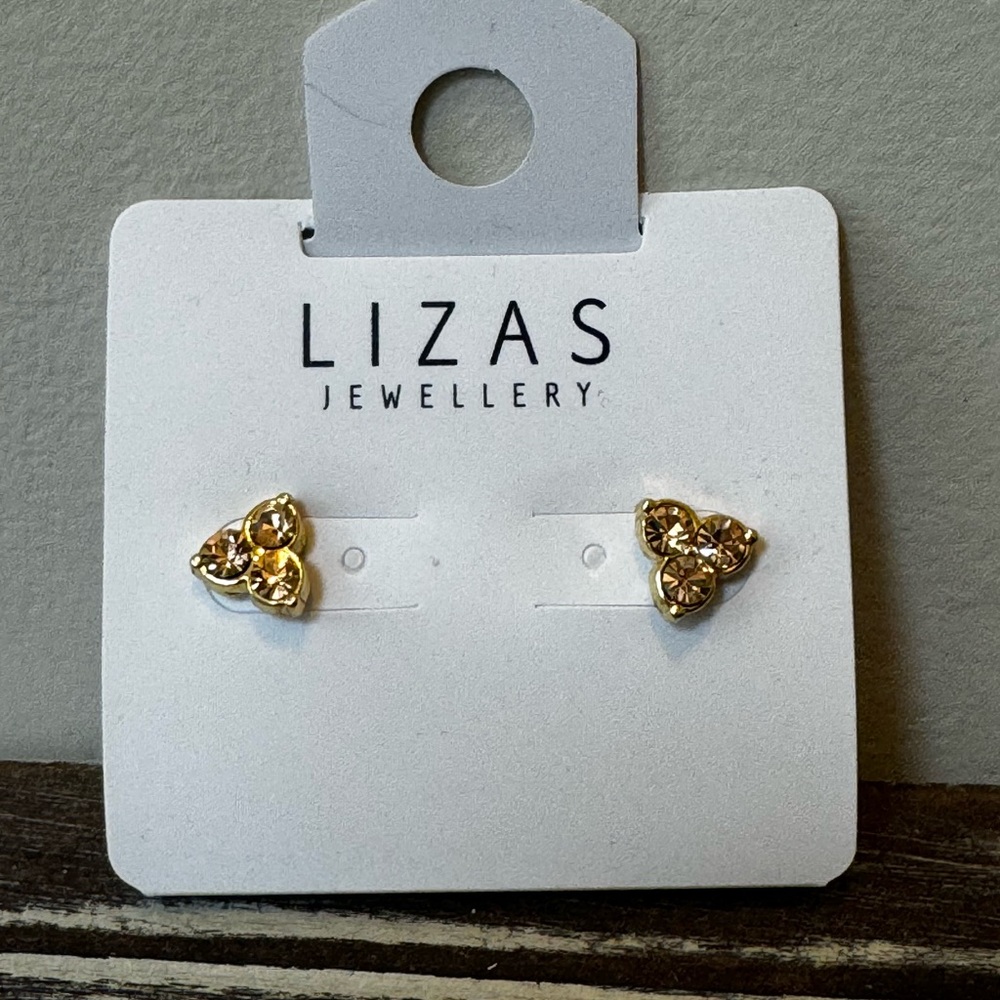 Crystal stud earrings in gold color, round settings.